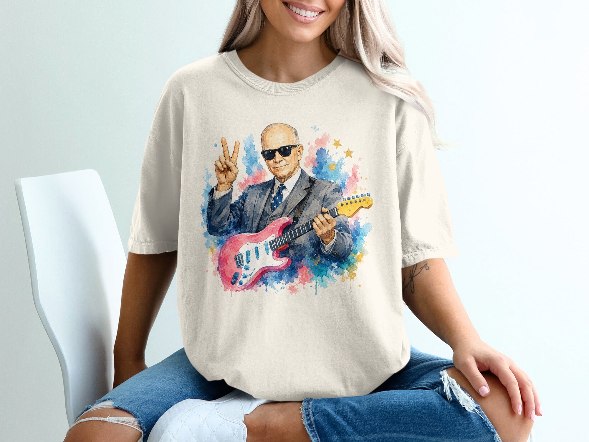 Man in suit and sunglasses playing pink electric guitar with watercolor splashes.