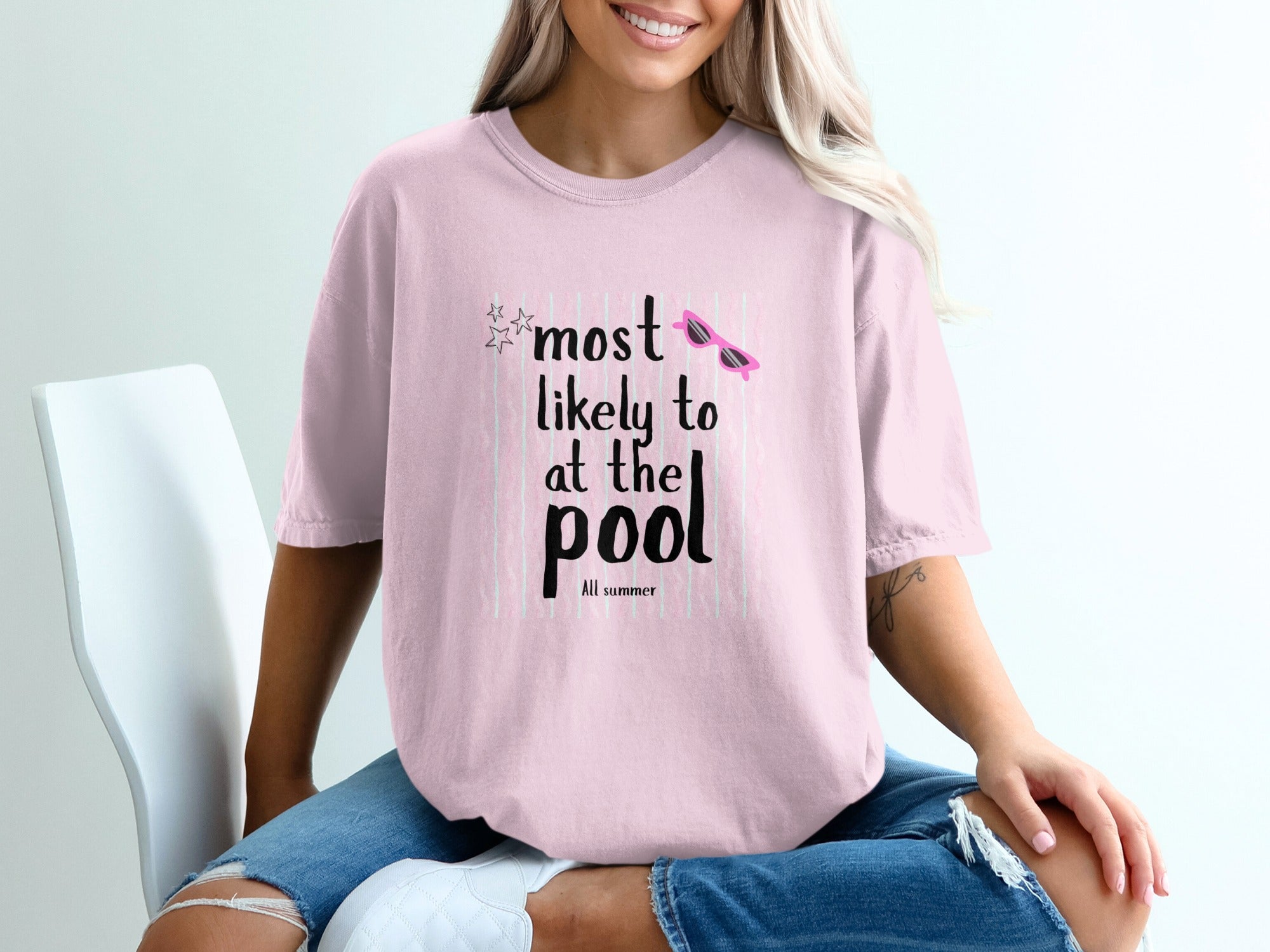 Pink t-shirt with "Most Likely to at the pool" graphic and pink sunglasses.