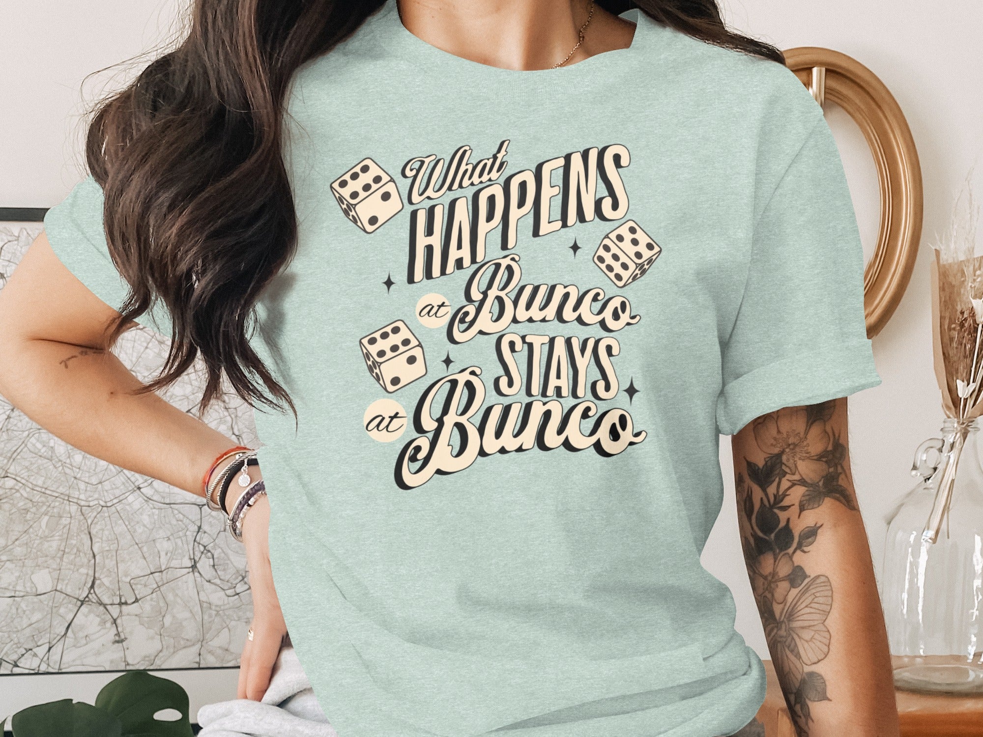 Light blue t-shirt with dice and text "What Happens at Bunco Stays at Bunco".