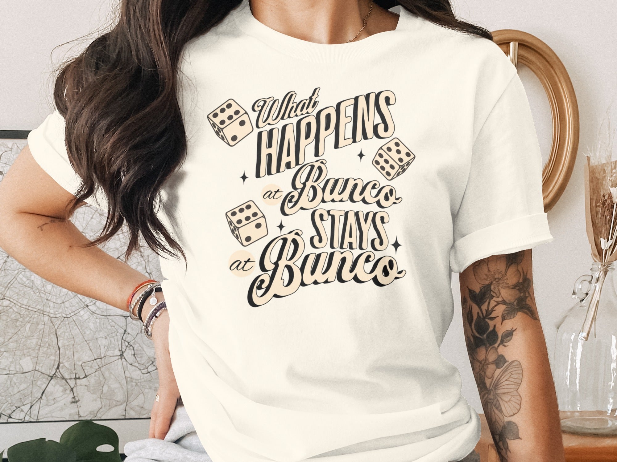 Cream t-shirt with "What HAPPENS at Bunco STAYS at Bunco" text and dice.