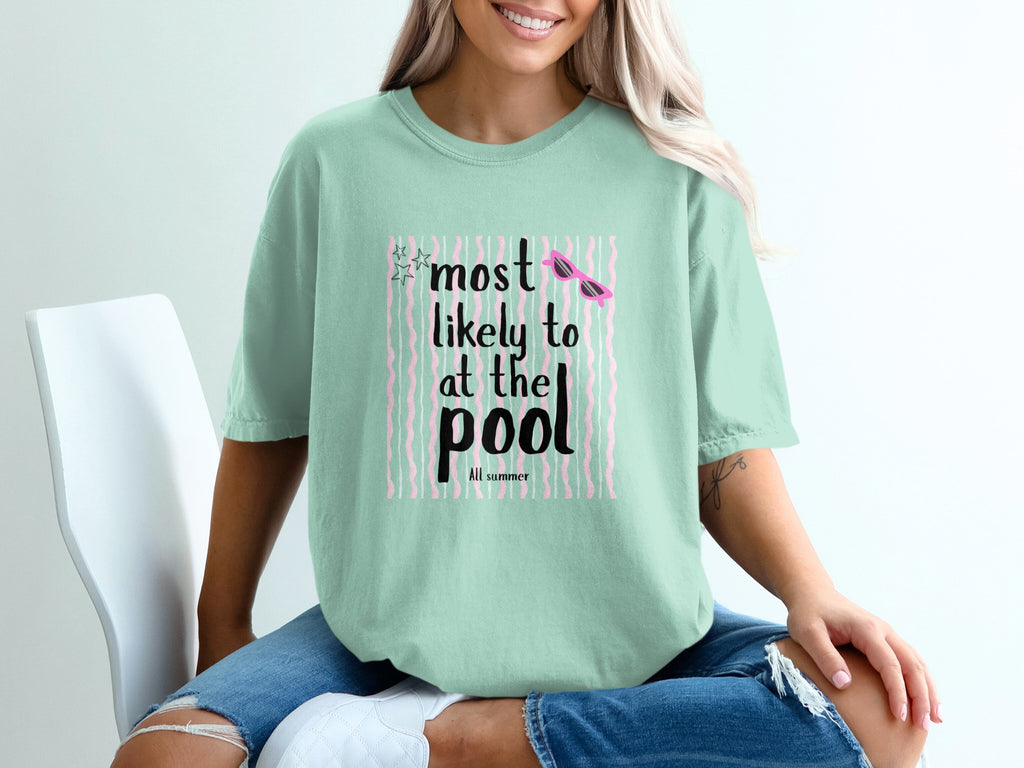 Crewneck t-shirt with "most likely to at the pool" text and pink sunglasses.