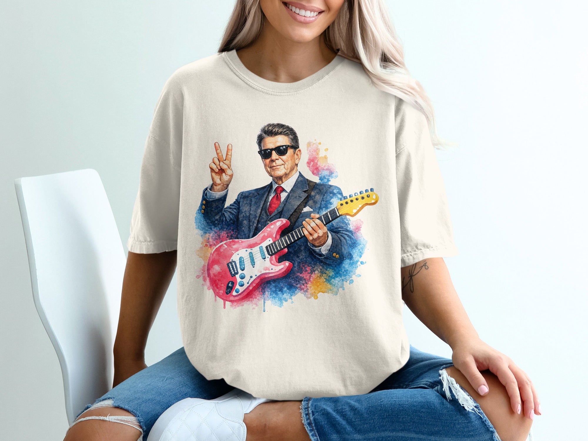 Man in suit playing electric guitar, making peace sign.