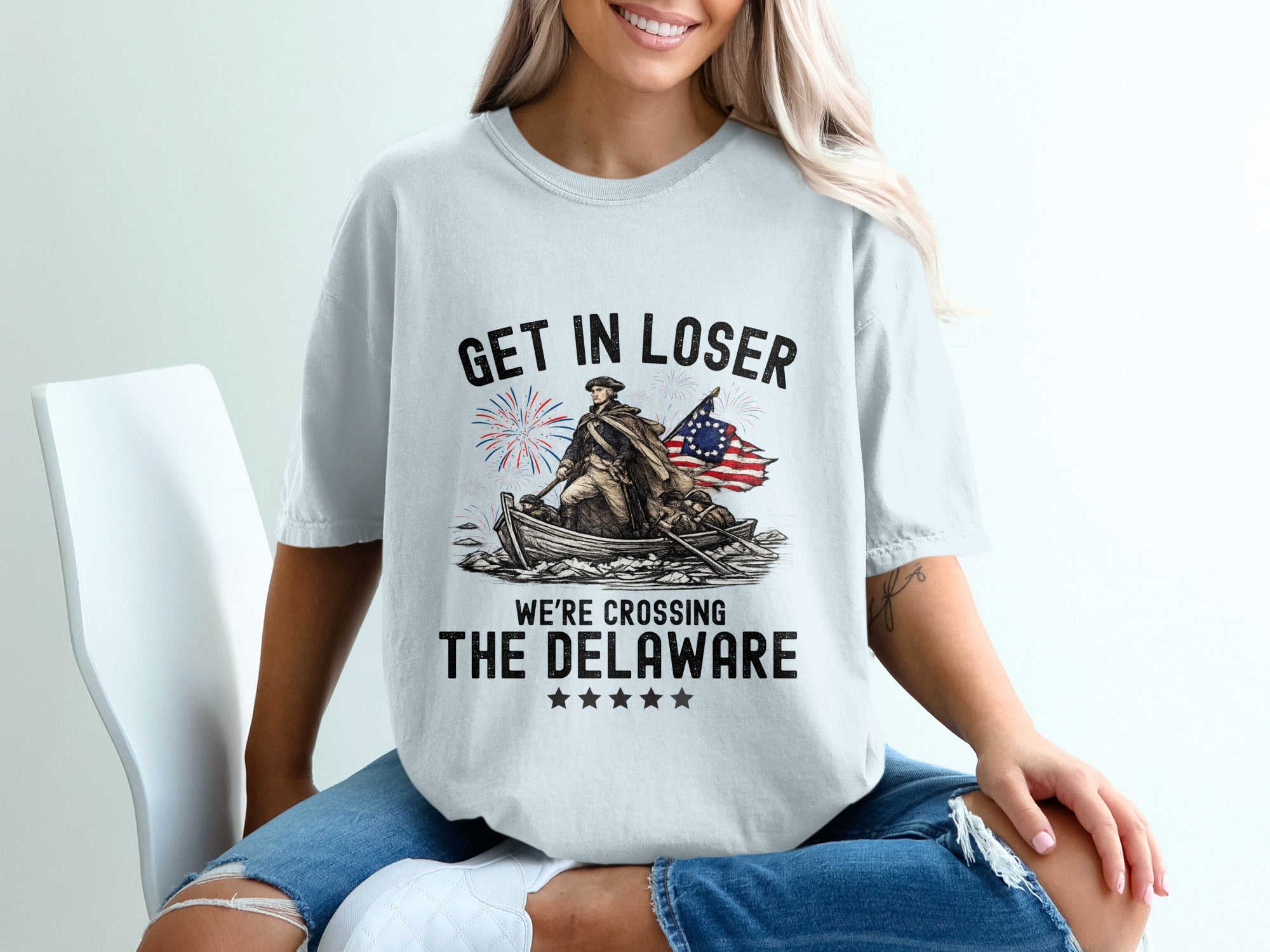 T-shirt graphic of a colonial soldier rowing across the Delaware River.