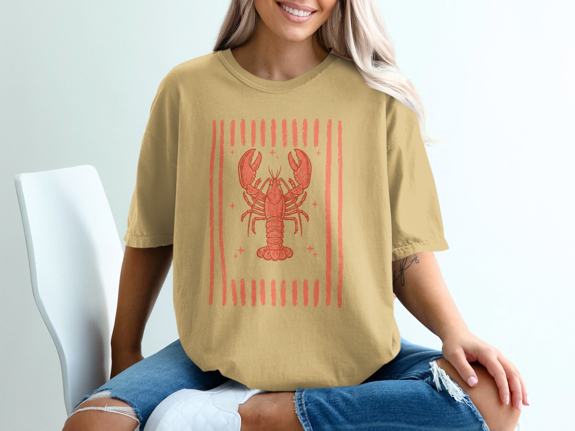 T-shirt with a coral lobster graphic inside a striped border.