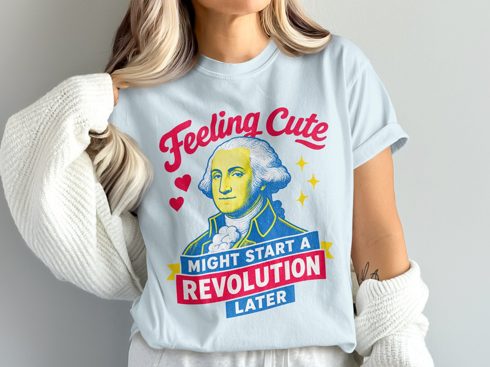 Light blue t-shirt with George Washington graphic and "Feeling Cute Might Start a Revolution Later" text.