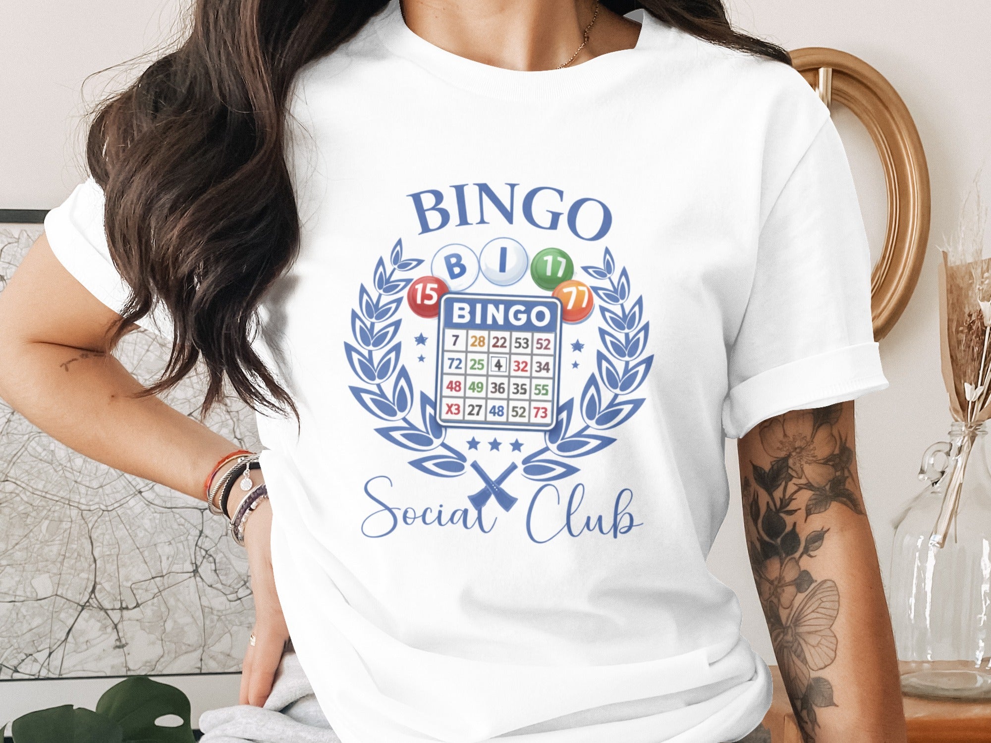 White t-shirt featuring a bingo card graphic with "BINGO" and "Social Club" text.