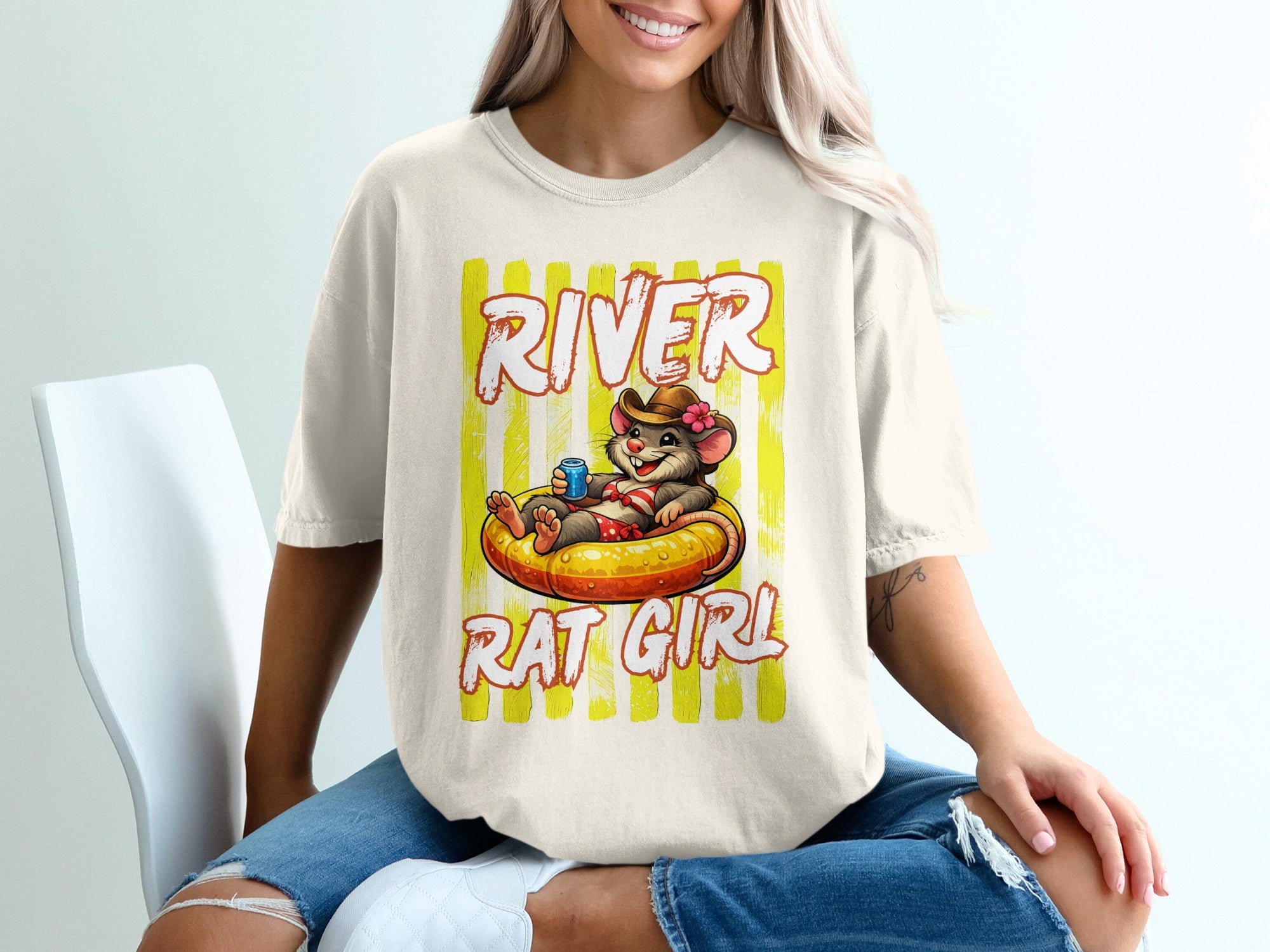 T-shirt graphic with text "RIVER RAT GIRL" and a mouse in a cowboy hat on an inner tube.
