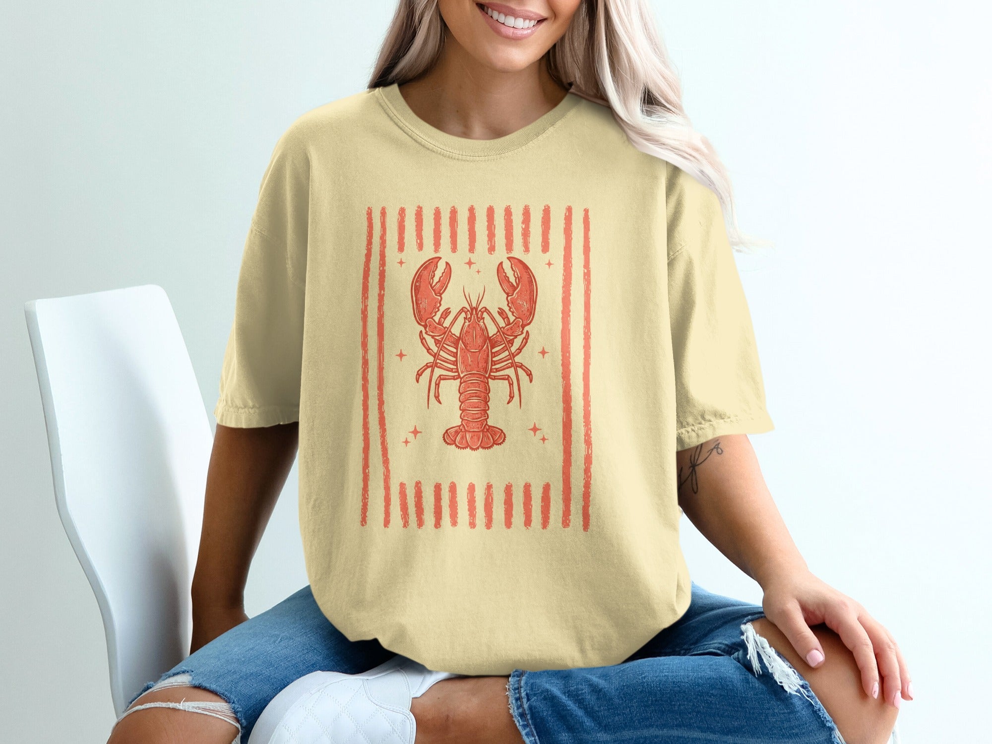 Yellow t-shirt with a red lobster graphic and vertical stripes.