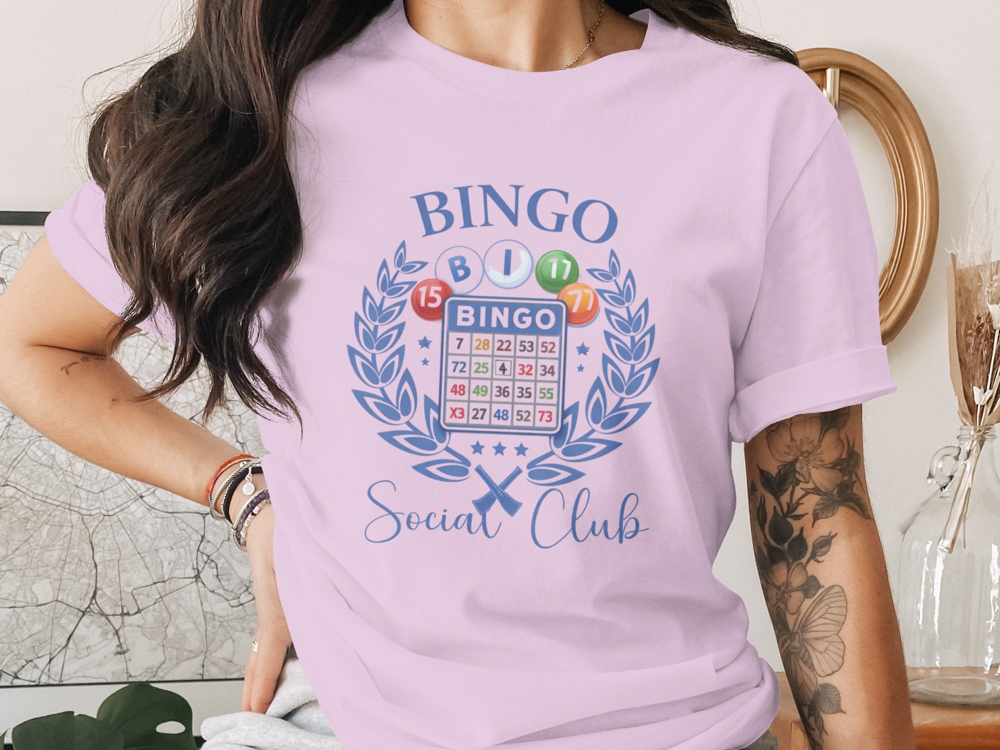 Bingo Social Club graphic with bingo cards and balls on a lavender t-shirt.
