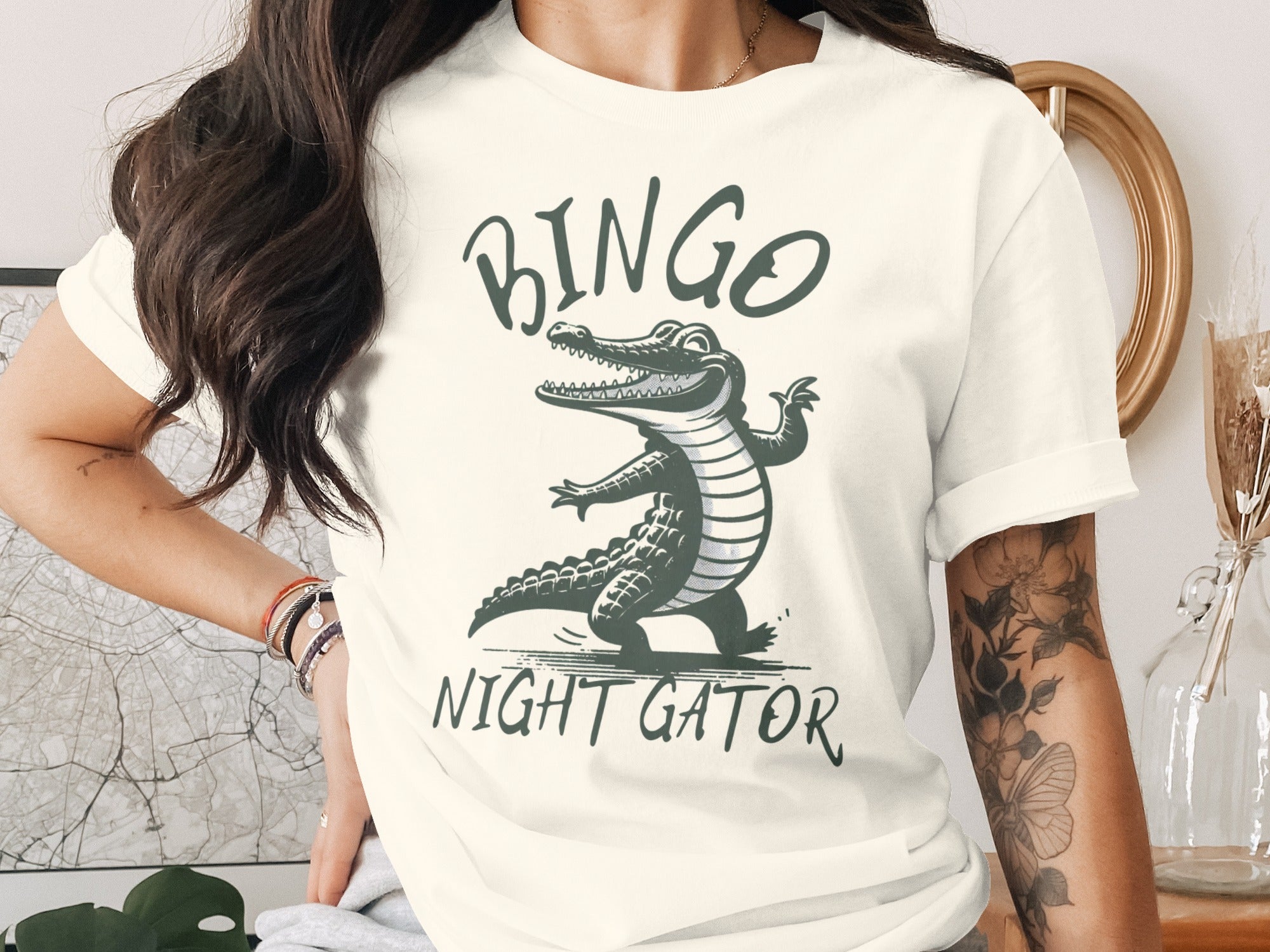 Cream t-shirt with graphic of cartoon alligator on it reading "BINGO NIGHT GATOR".